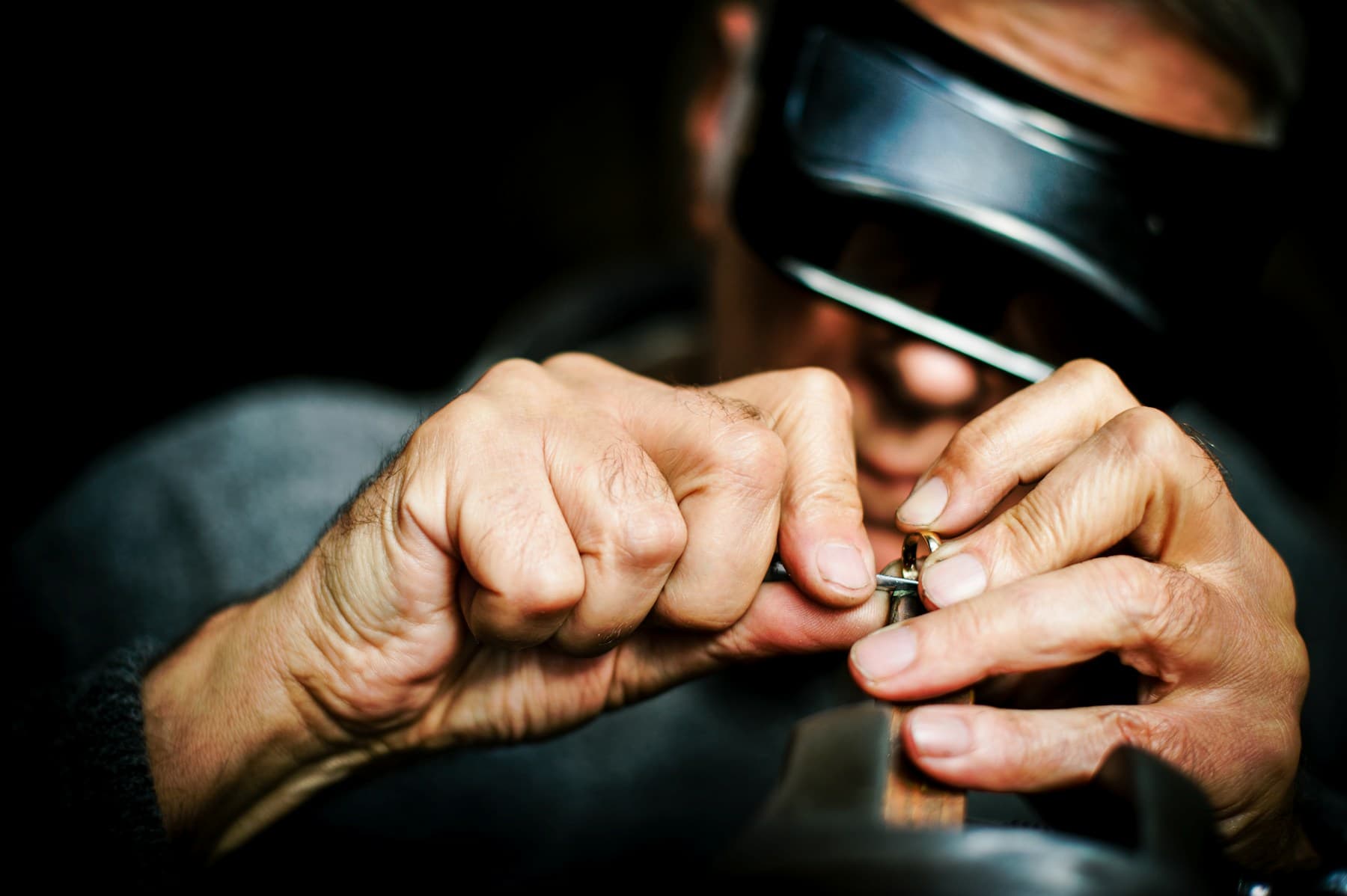 Goldschmied arbeitet mit der Lupe konzentriert an einem Ring